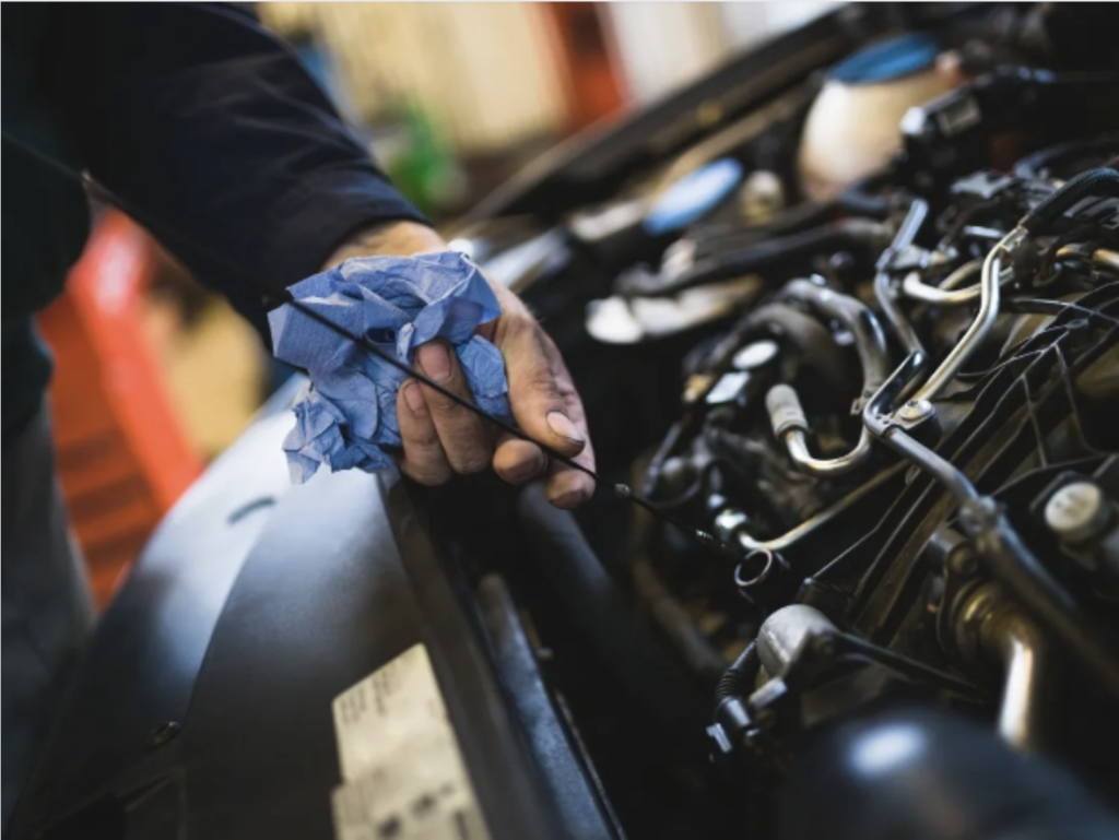 Vérification de l'huile par un mécanicien expérimenté - Un entretien automobile méticuleux pour une performance optimale.