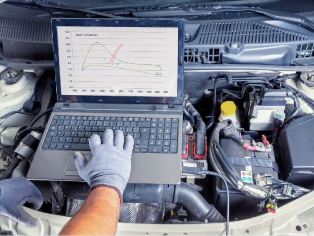 Diagnostic automobile avancé : ordinateur en train d'analyser le moteur d'une voiture pour une réparation précise