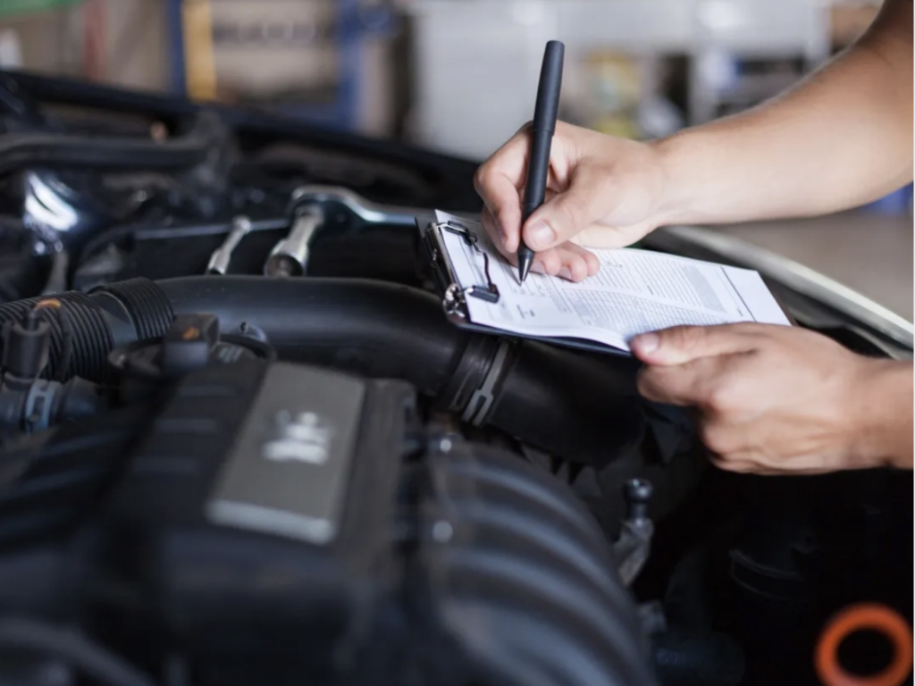 Inspecteur prenant des notes lors d'une inspection préachat : Engagement envers la transparence et l'assurance d'un achat automobile éclairé